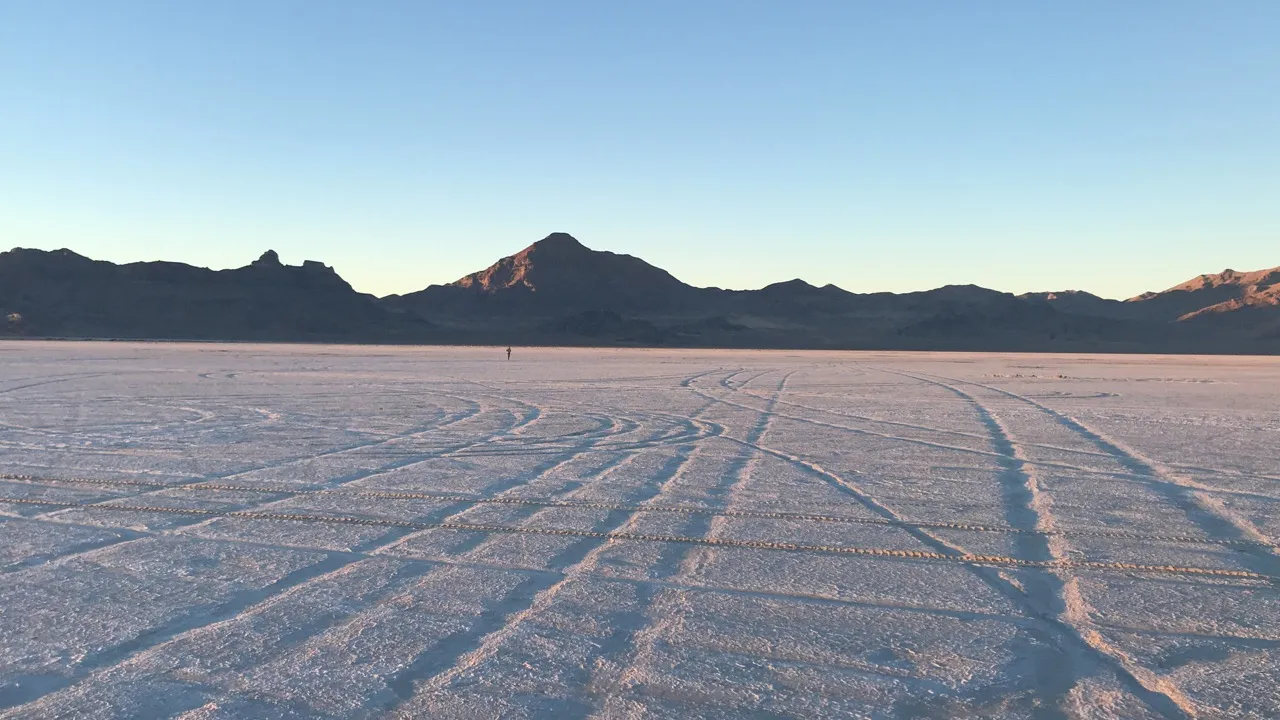 Tire tracks across the Bonneville Salt Flats in Utah, mountains on the horizon