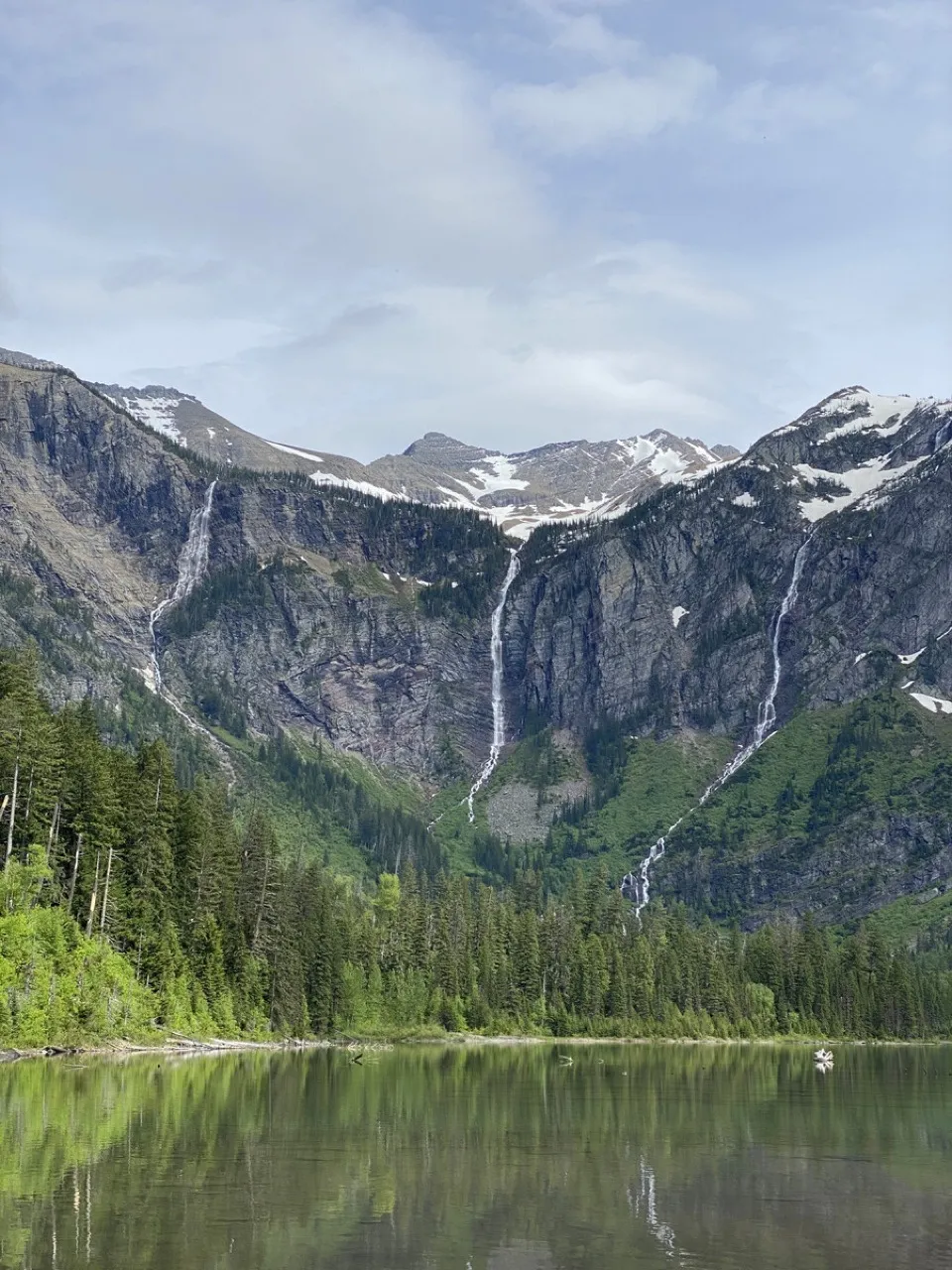 Avalanche Lake in Glacier National Park, waterfalls running down the cliffs